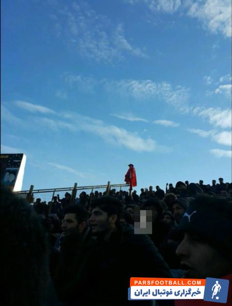 تصویری از طرفدار تراکتورسازی با کلاه و شنل در ورزشگاه یادگار امام